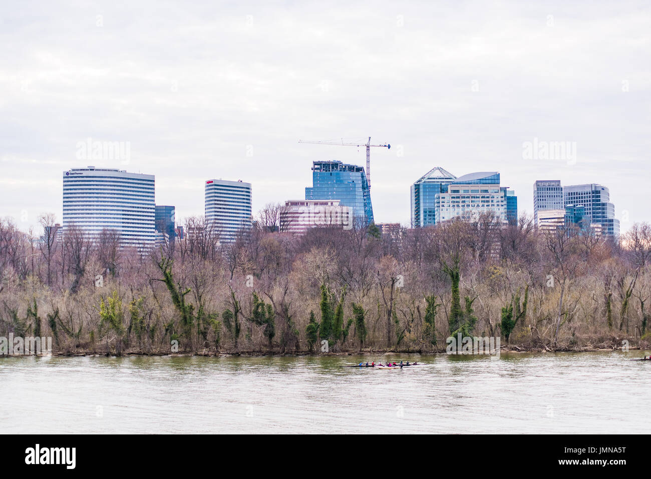 Washington DC, USA - 20 mars 2017 : Les gens de l'aviron sur la rivière Potomac, sur un bateau avec des toits de gratte-ciel d'Arlington en Virginie Banque D'Images