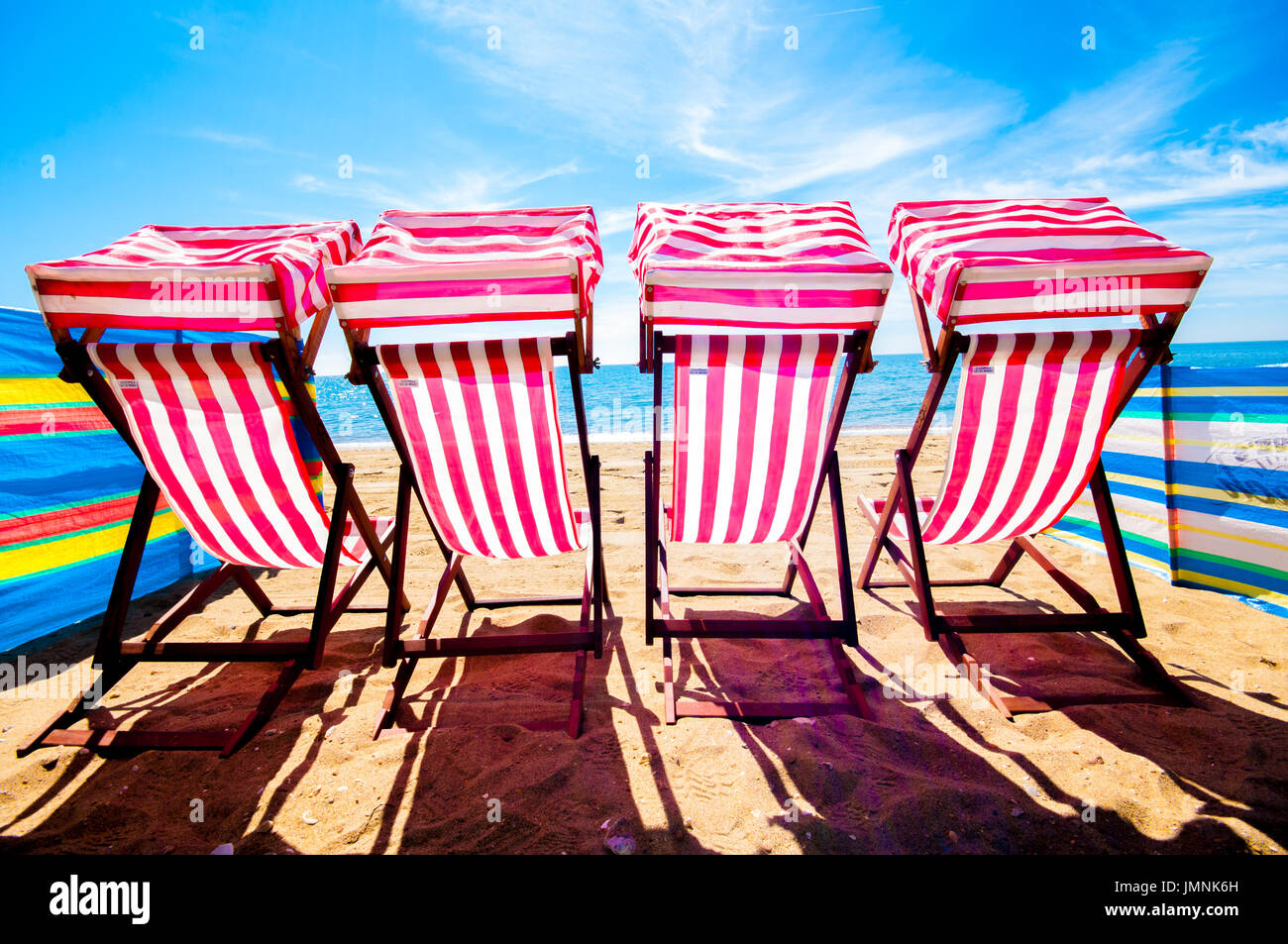 Quatre chaises sur la plage de sable à l'été ensoleillé jour ciel bleu Banque D'Images