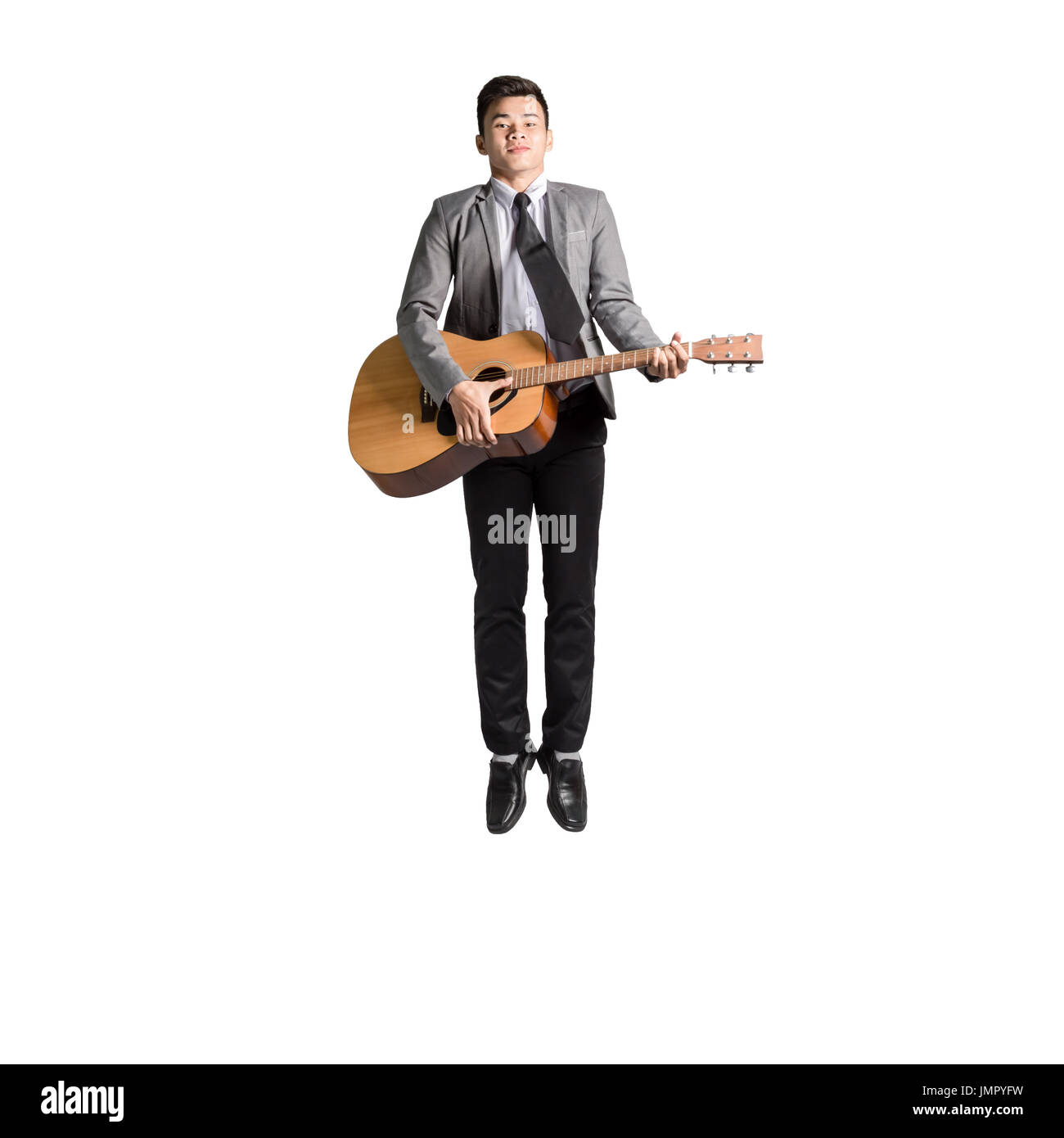 Portrait of a young man jumping avec guitare. Isolé sur fond blanc avec copie espace Banque D'Images