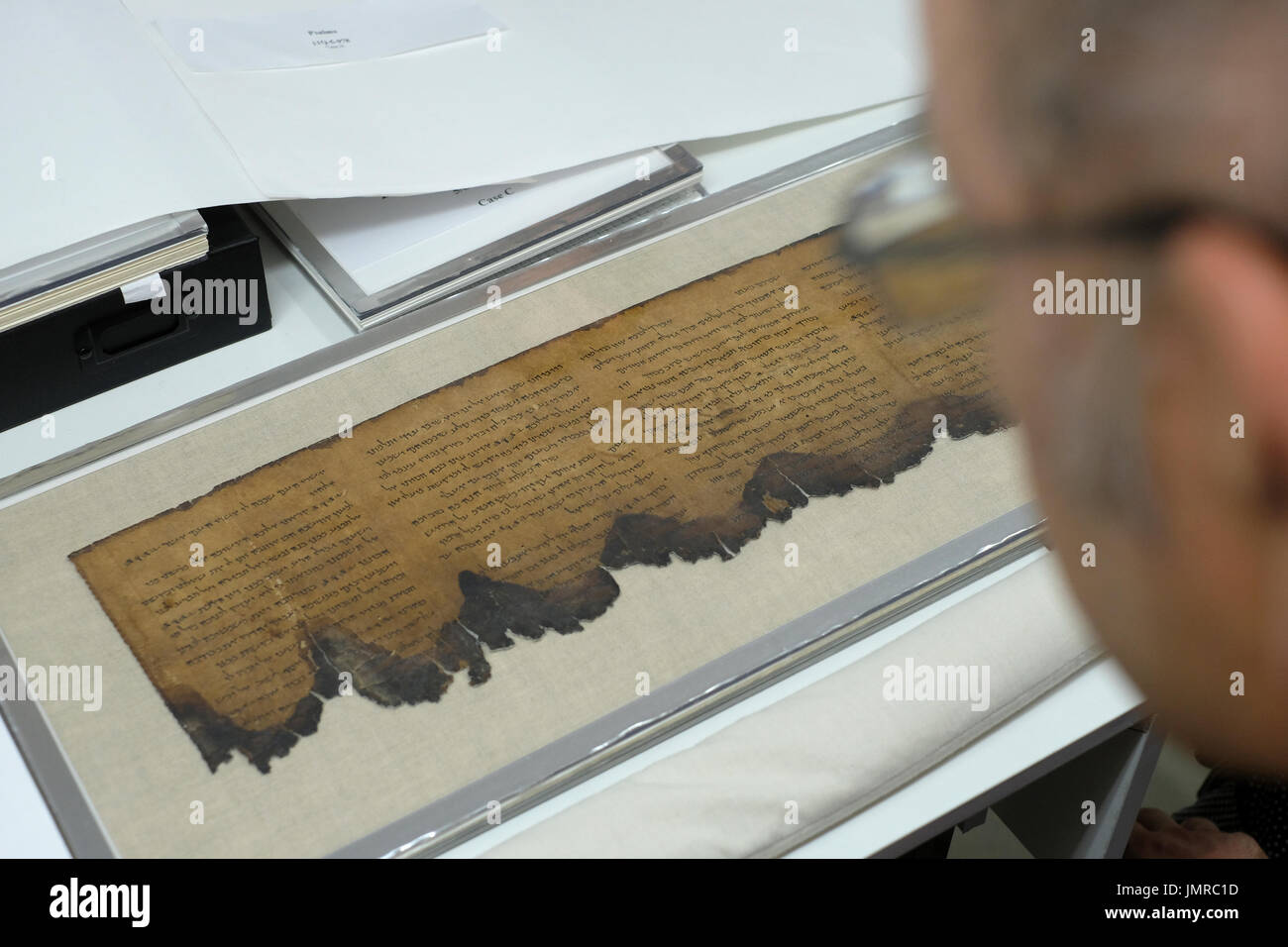Un homme inspecte un fragment de Mer Morte Psaumes livre écrit en hébreu trouvés à Qumran grottes dans le laboratoire de préservation de l'Autorité des antiquités d'Israël au Musée d'Israël à Jérusalem Israël Banque D'Images