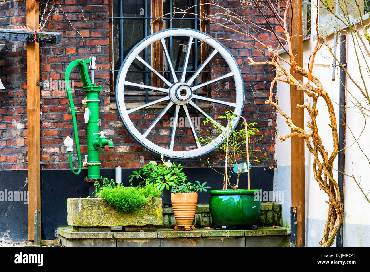 Décoration de jardin en bois, roue de chariot, pompe à eau divers matériaux de décoration. Banque D'Images