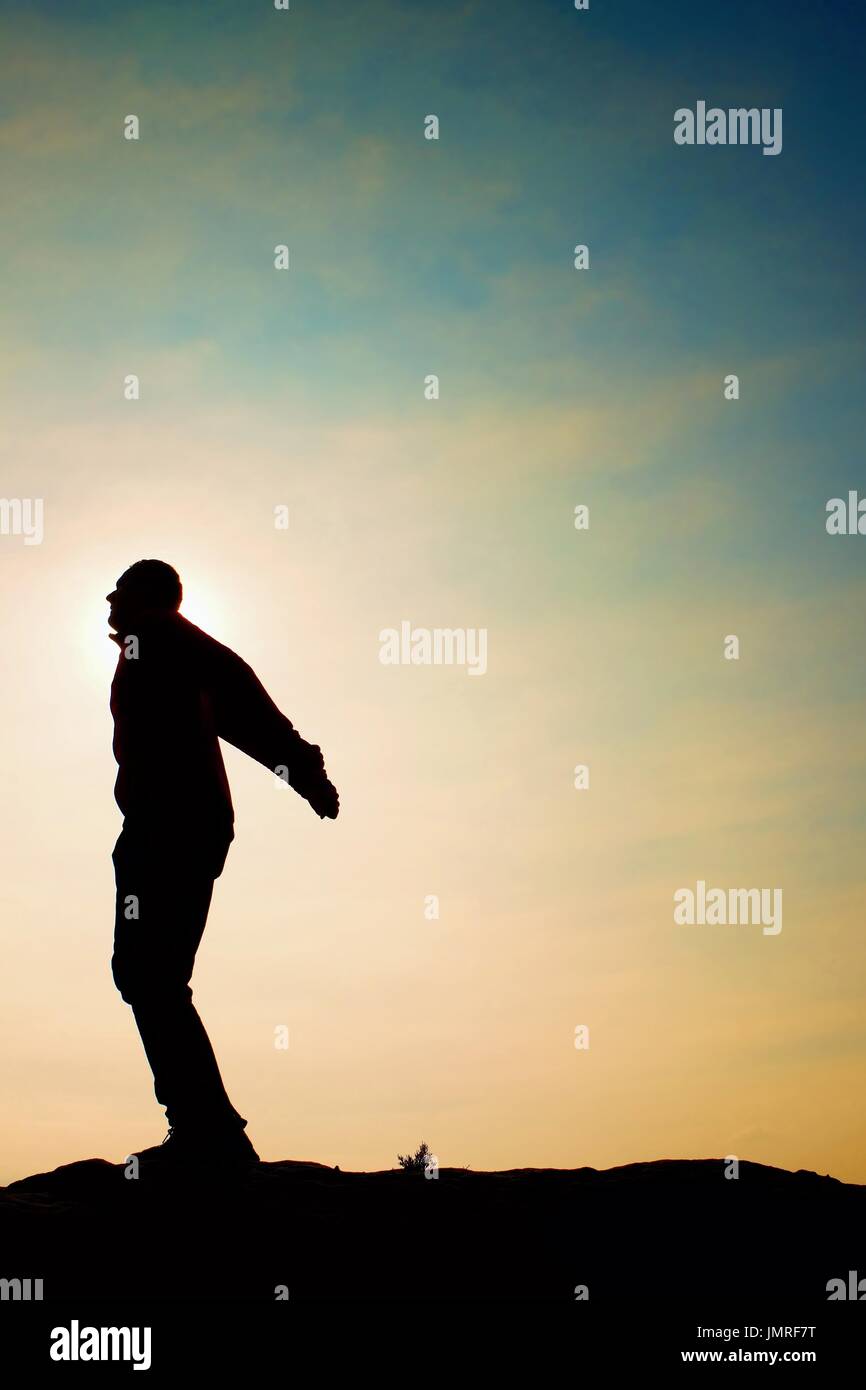 L'homme prêt à sauter. Des profils fou saute sur fond de ciel coloré.Silhouette de l'homme et beau coucher de ciel. Effet Vintage Banque D'Images