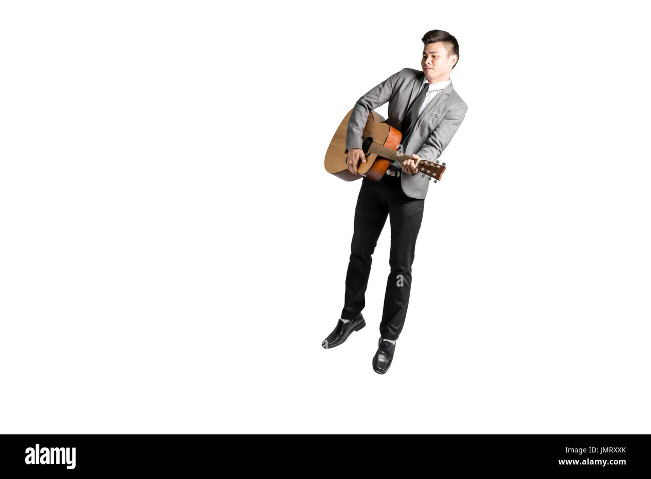 Portrait of a young man jumping avec guitare. Isolé sur fond blanc avec copie espace et chemin de détourage Banque D'Images