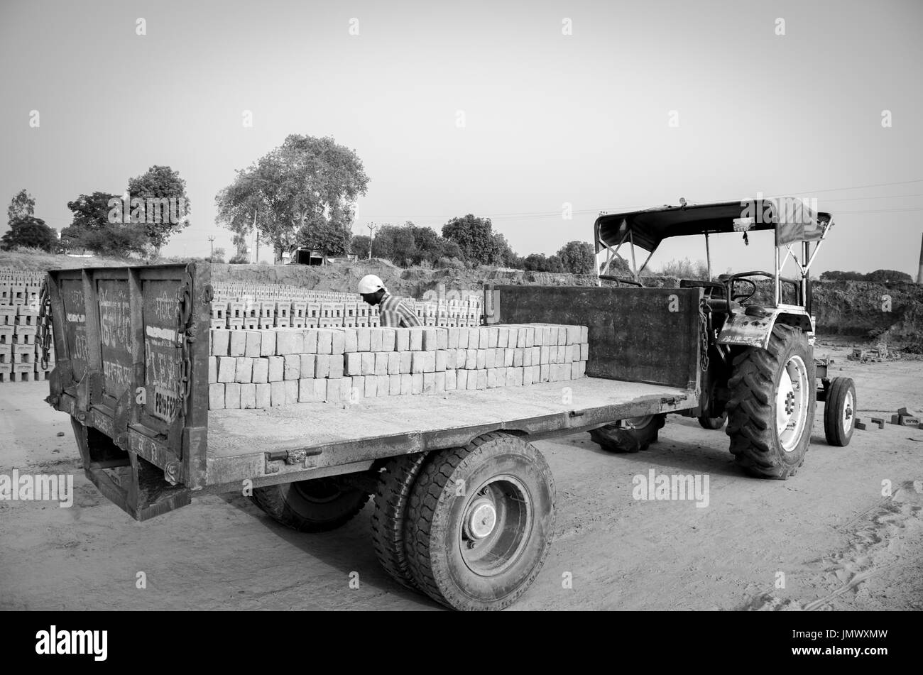 Amritsar, Punjab, india - 21 avril 2017 : photo monochrome de briques d'être chargé dans un camion par un travailleur prêt pour l'expédition à un marché de gros Banque D'Images