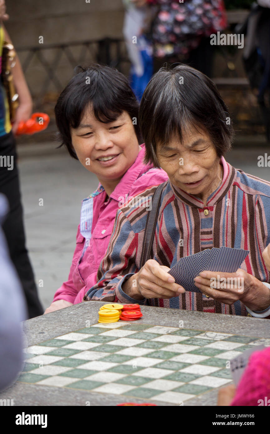 Une vieille femme chinoise cartes à jouer dans un seul jeu des femmes dans Columbus Park dans le quartier chinois, la ville de New York. Banque D'Images