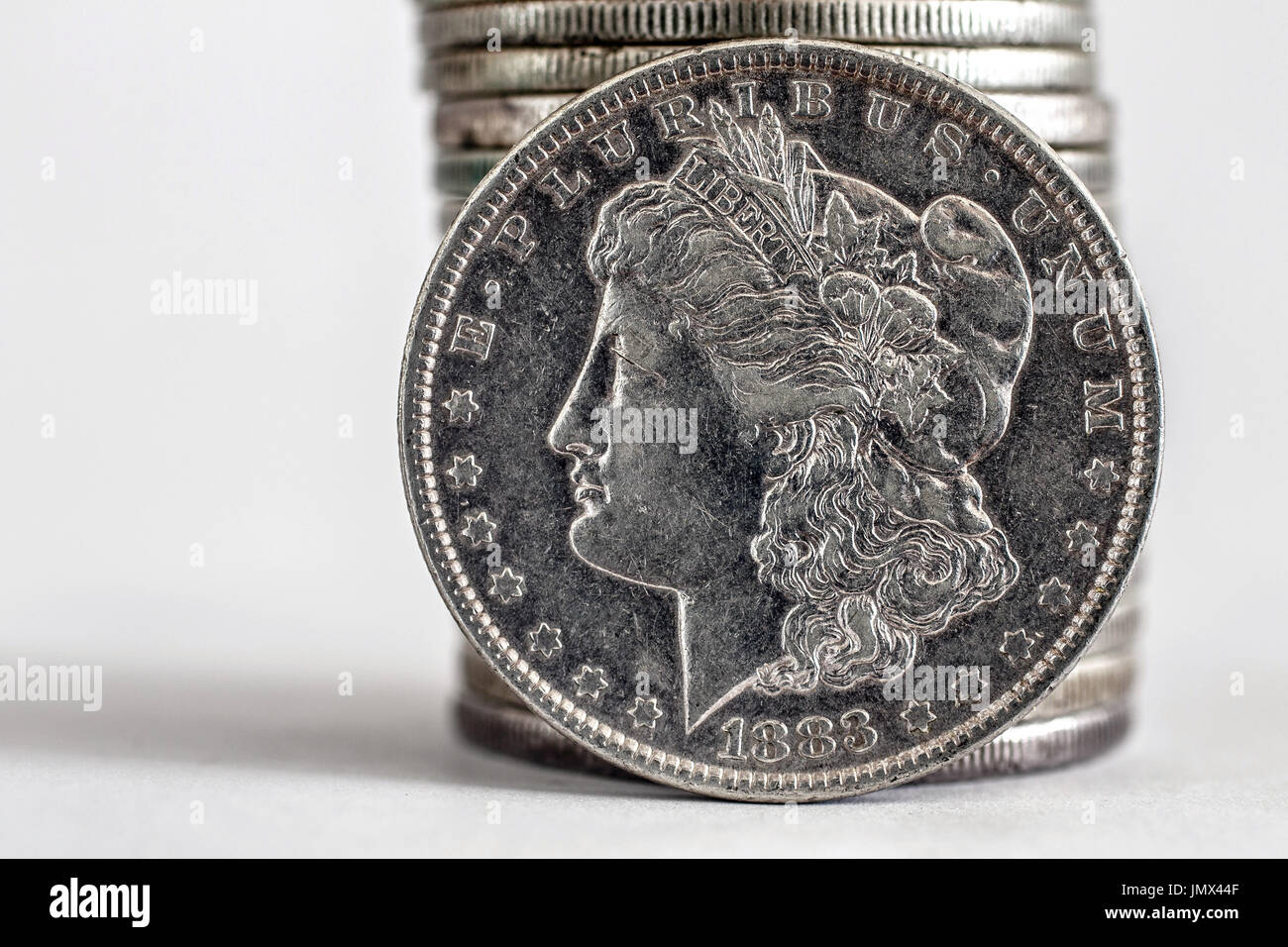 1883 Morgan Dollar se dresse contre une pile de pièces. Banque D'Images