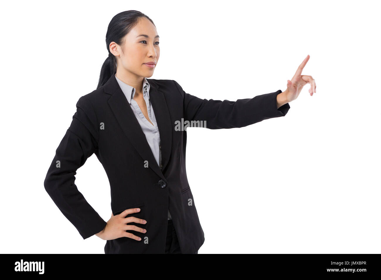 Businesswoman en appuyant sur un écran virtuel invisible contre fond blanc Banque D'Images