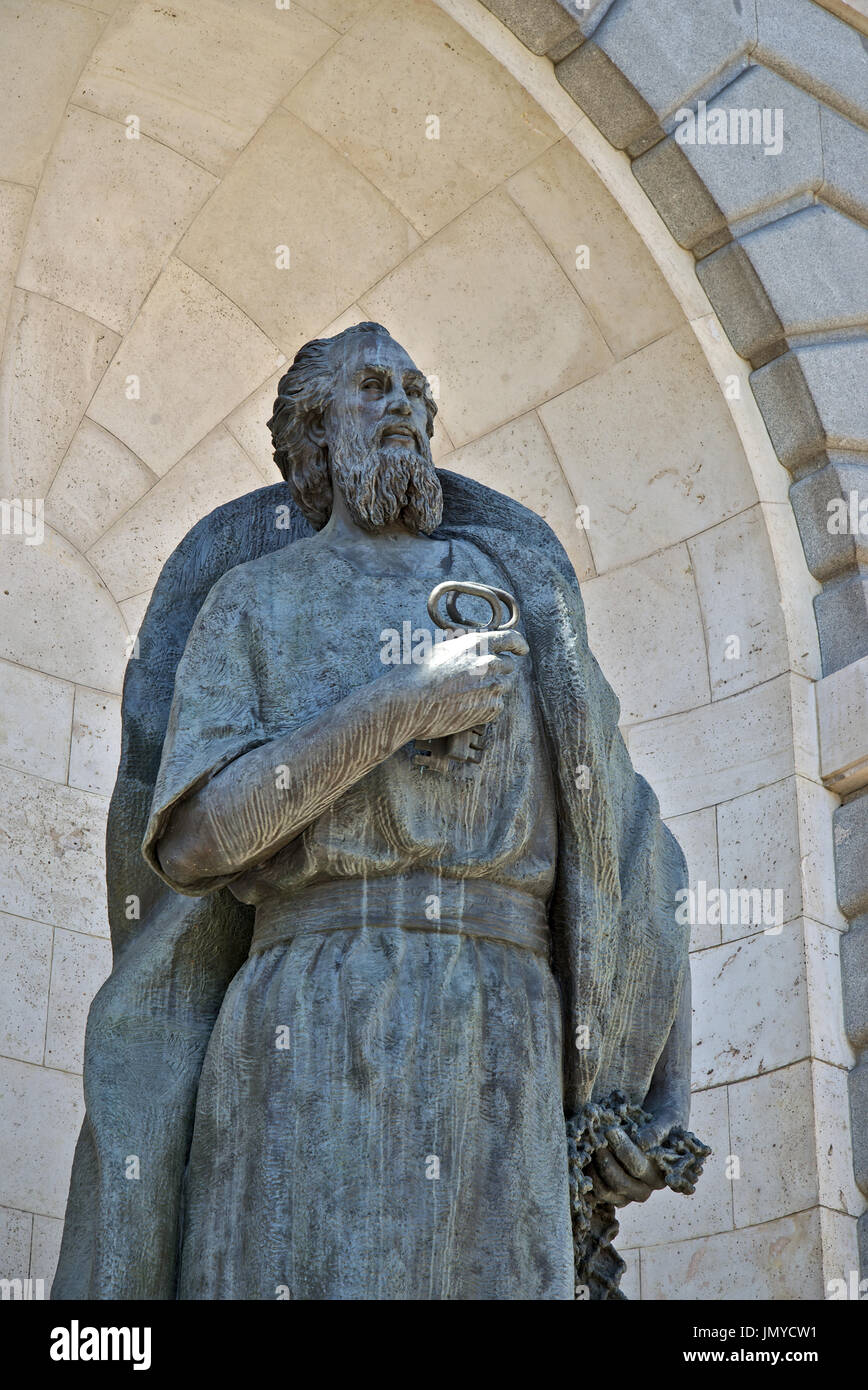 Touches holding bronze statue de Saint Pierre, placé à côté de la façade principale de la cathédrale de la Almudena, la cathédrale principale de Madrid, Espagne. Banque D'Images