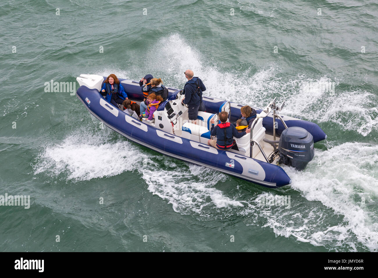 Famille et chien dans Avon Inflatable Boat boating dans le Solent entre Lymington et Yarmouth, Isle of Wight, Hampshire, Royaume-Uni en juillet Banque D'Images