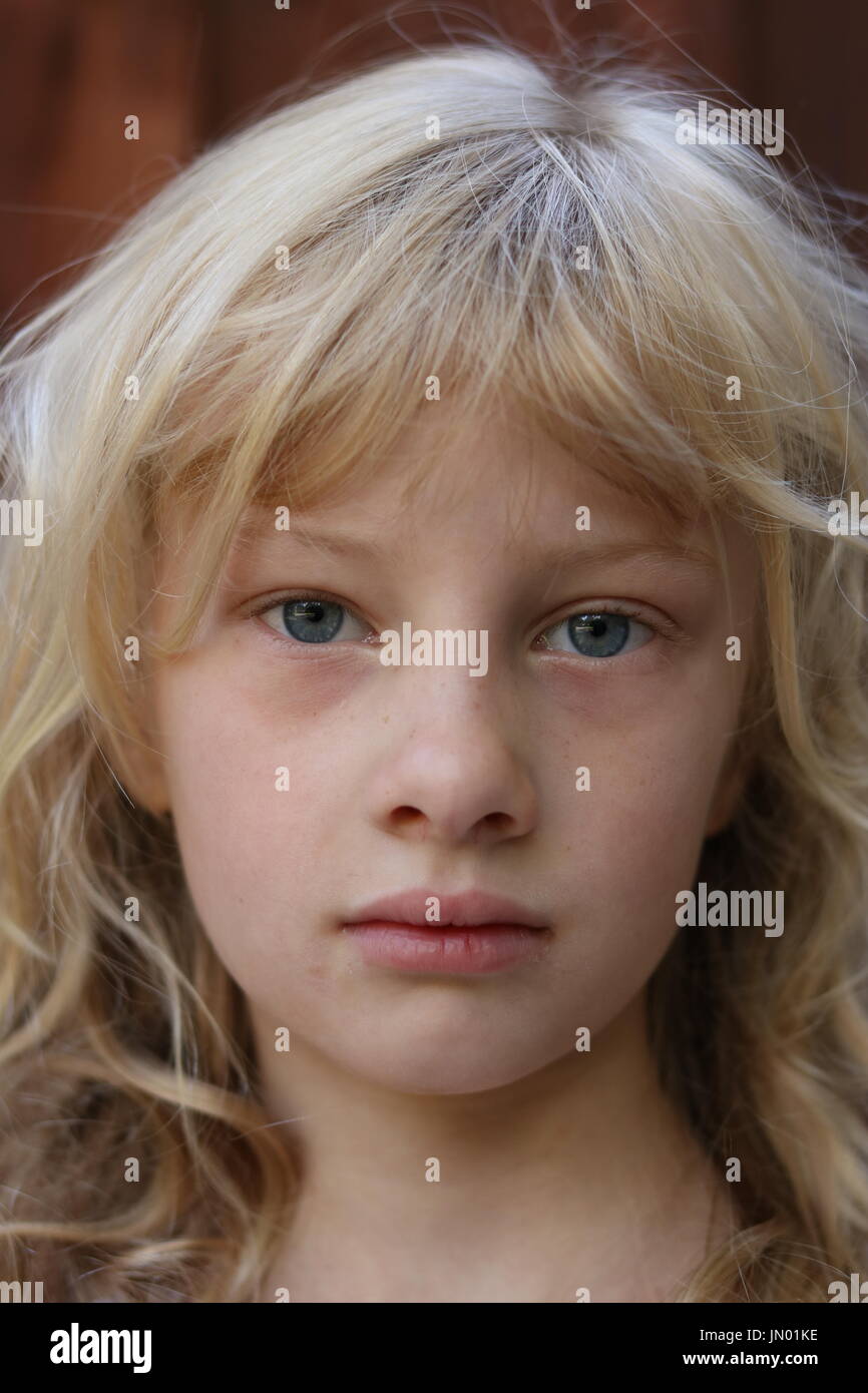 Portrait d'une jeune fille blonde aux yeux bleus avec un regard solennel Banque D'Images