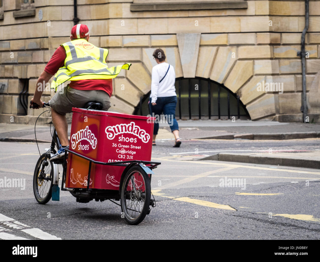 Un cavalier et vélo de cargaison appartenant à l'entreprise de livraison du dernier kilomètre franc stationné dans le centre historique de Cambridge, au Royaume-Uni. Banque D'Images