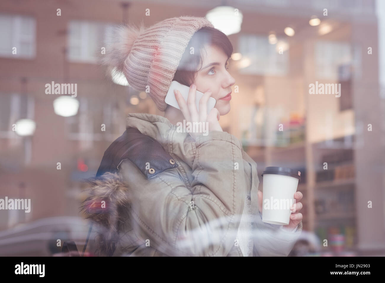 Young Woman talking on mobile phone in store Banque D'Images