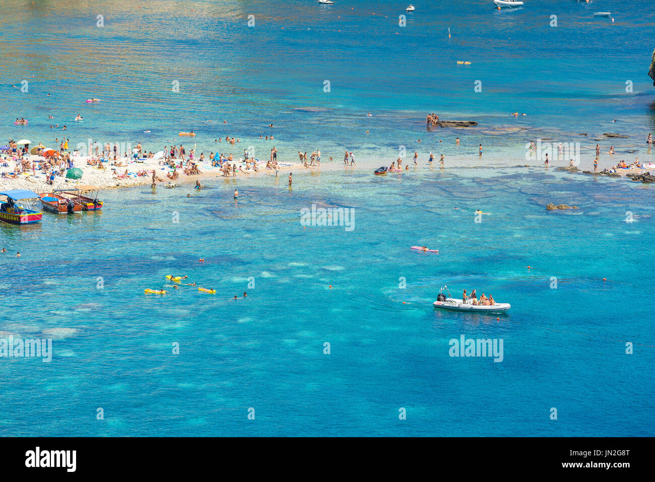 Sicile plage, vue en été des siciliens bains de soleil dans une crique pittoresque à la plage de Mazzaro près de Taormina, Sicile. Banque D'Images