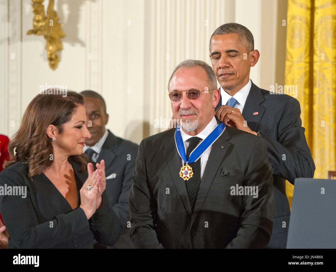 Gloria Estefan applaudit comme son mari Emilio Estefan reçoit la Médaille présidentielle de la liberté du Président des Etats-Unis Barack Obama lors d'une cérémonie dans l'East Room de la Maison Blanche à Washington, DC le Mardi, Novembre 24, 2015. La médaille est la plus haute distinction civile US, a présenté à des personnes qui ont contribué en particulier à la sécurité contribution méritoire ou d'intérêts nationaux des États-Unis, pour la paix dans le monde, ou de la ou des entreprises publiques ou privées. Credit : Ron Sachs / CNP Banque D'Images