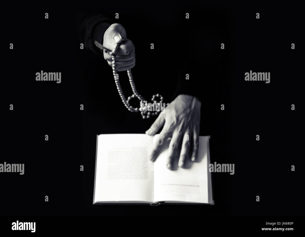 Les jeunes mains qui prient avec un chapelet et la Sainte Bible. La religion concept photo en noir et blanc Banque D'Images