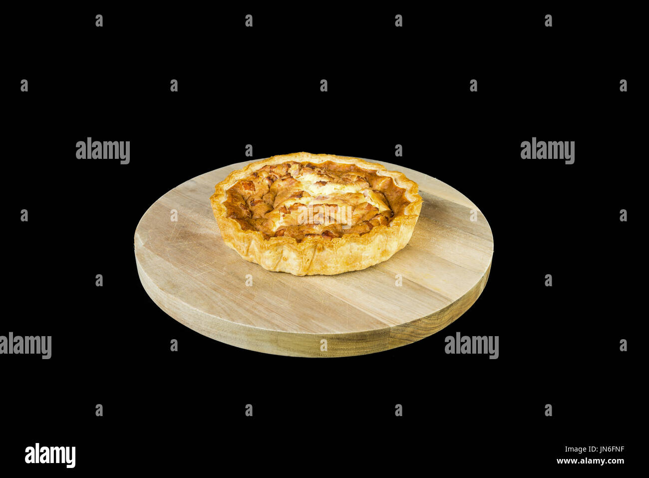 Une nouvelle quiche lorraine au four sur un sol en bois servant de sélection et isolé sur un fond noir Banque D'Images