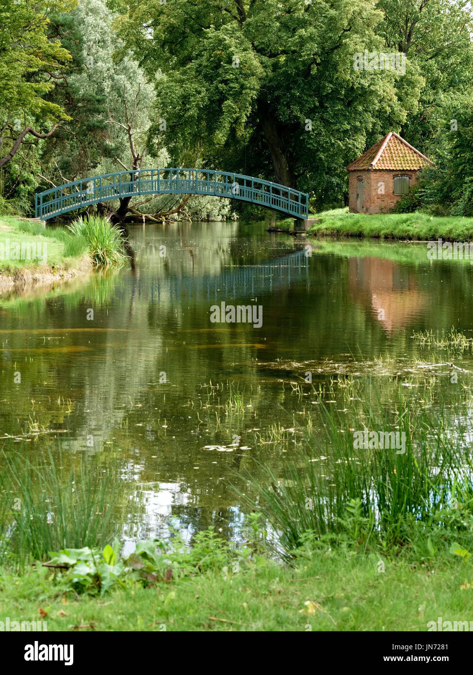 C'est pas arche unique passerelle piétonne en bois sur le lac dans le parc de doddington hall estate, Lincolnshire, Angleterre, RU Banque D'Images