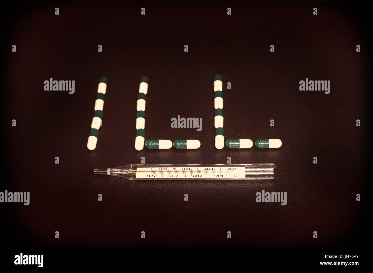 Thermomètre médical et des pilules sur un fond noir en cuir. Antécédents médicaux. Banque D'Images