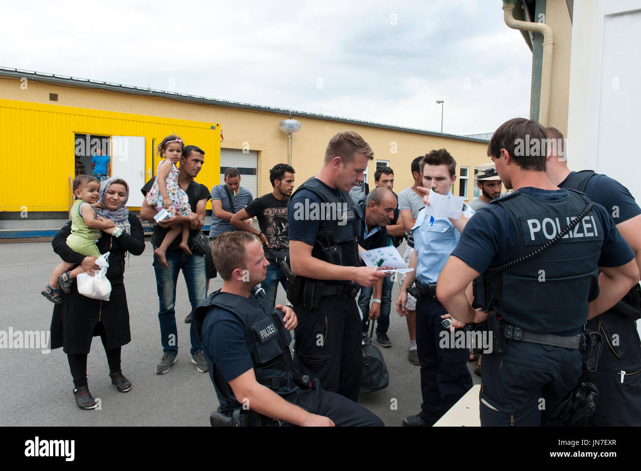 Passau, Allemagne - 1er août 2015 : La police prend les informations de réfugiés dans le centre d'enregistrement temporaire pour les migrants et les réfugiés. Banque D'Images