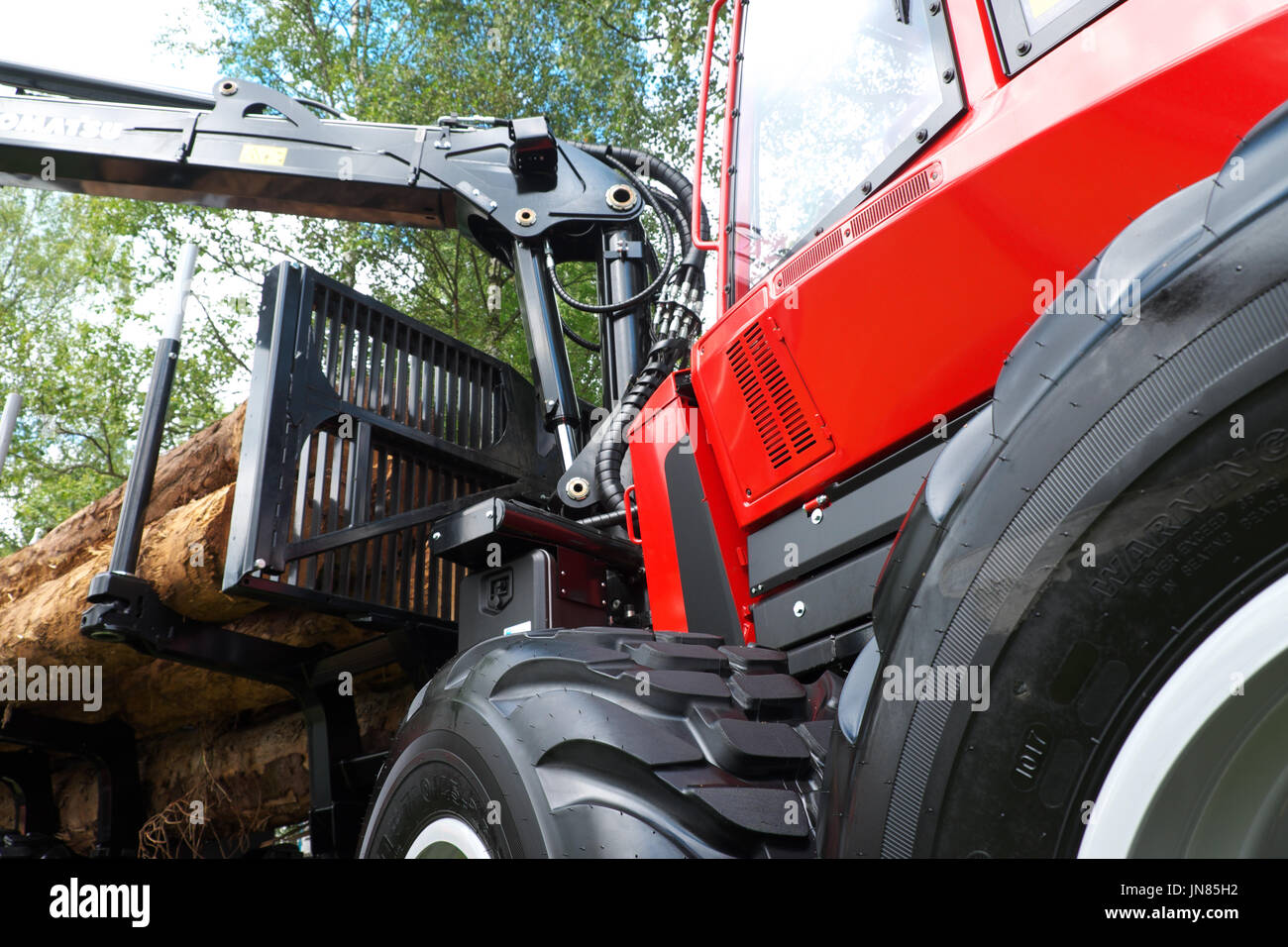 L'industrie forestière tracteur avec bras de maintien et de tronc de l'arbre de sciage sur remorque UK Banque D'Images