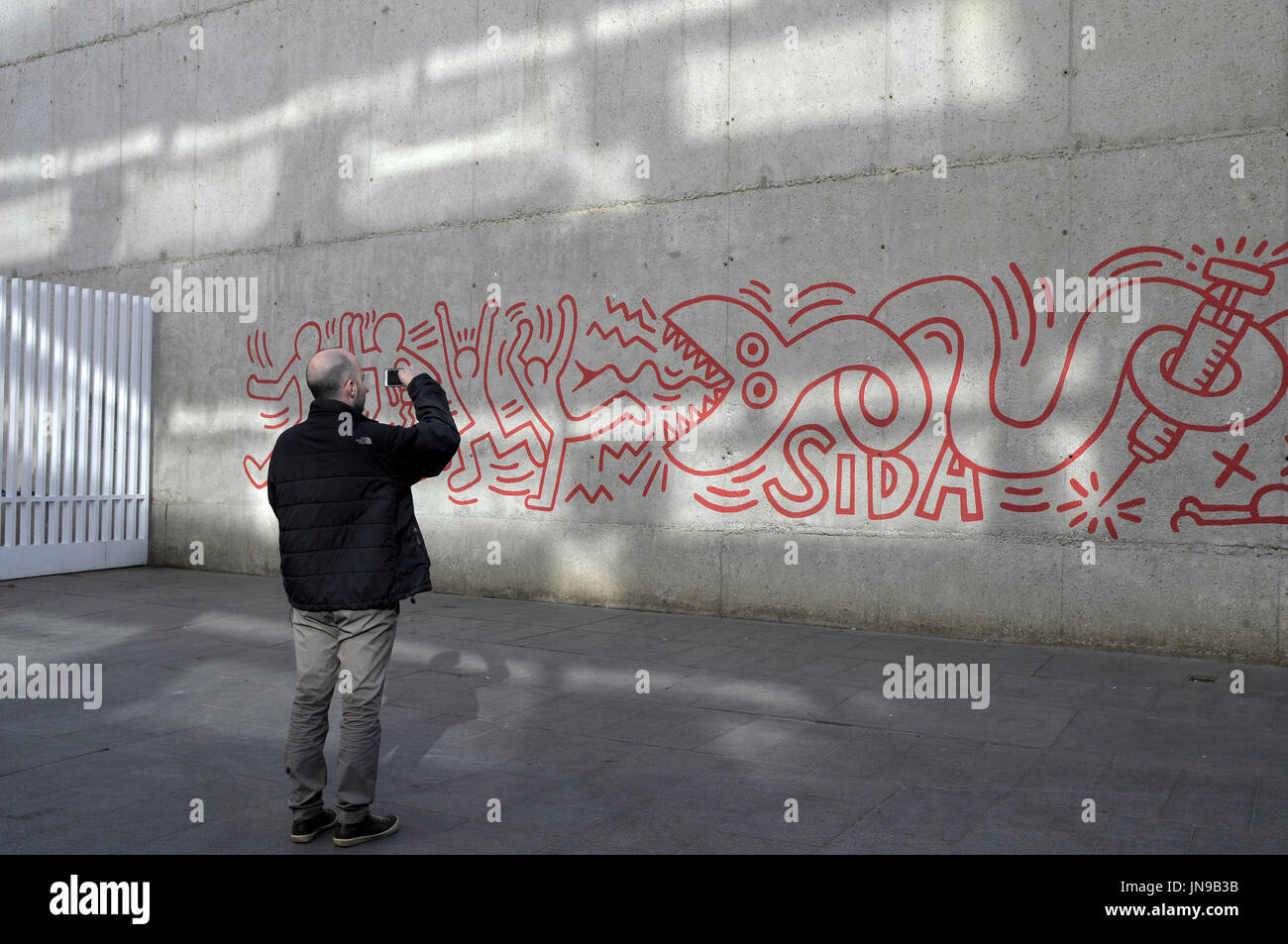 Un homme taiking une photo du grafitti par K. Haring 1989. Le quartier de El Raval. Cour du musée MACBA, Barcelone. foto : Rosmi Duaso, Banque D'Images