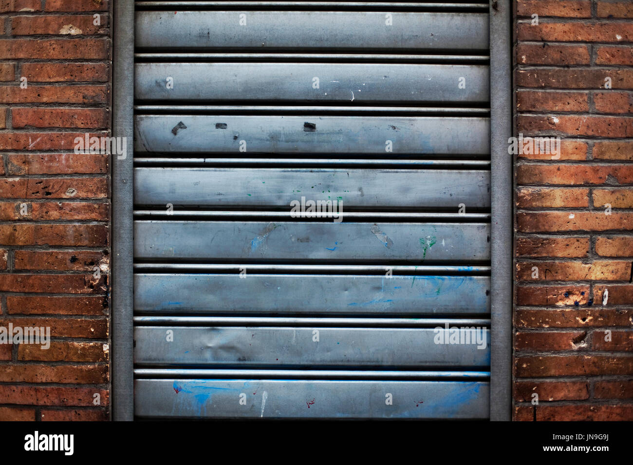 Rideau de fer fermé et mur de brique Banque D'Images