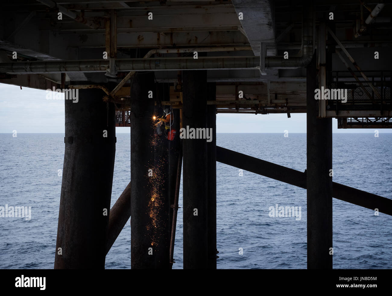Un accès sur corde (industriel) irata de soudure, d'un caisson d'une mer du Nord sur une plate-forme de pétrole et de gaz. crédit : lee ramsden / alamy Banque D'Images