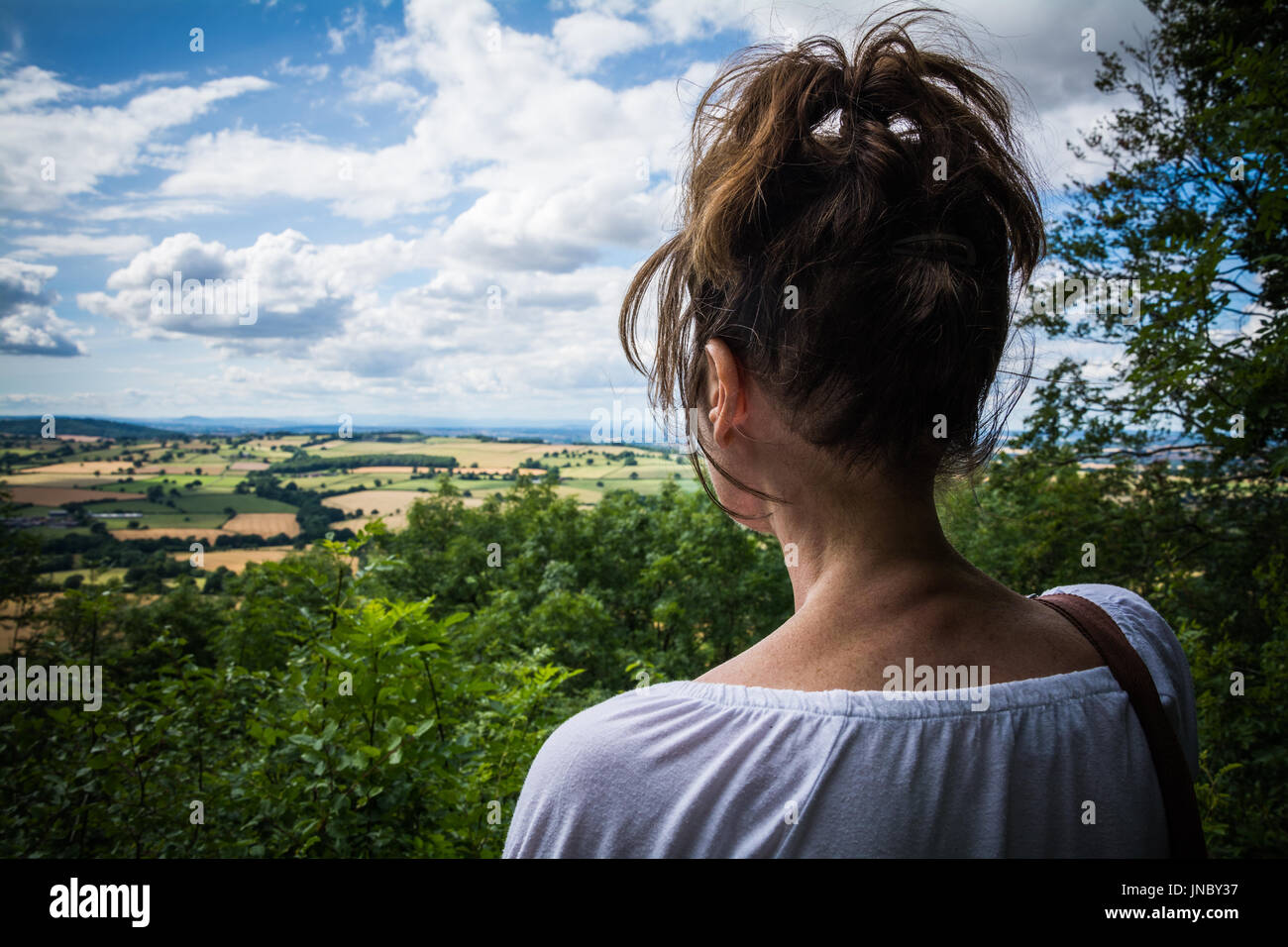 Femme à la recherche de l'ouest à travers Wenlock Edge. À la recherche d'un concept, qu'en regardant dans la distance, pour l'avenir. Le Shropshire, au Royaume-Uni. Banque D'Images