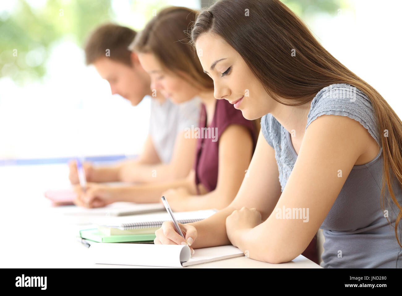 Vue de côté trois concentrés les élèves qui étudient la prise de notes à l'école Banque D'Images