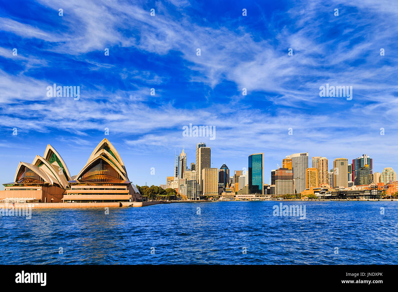 Panorama de la ville de Sydney CBD derrière Circular Quay dans tout port avec de hautes tours d'affaires et de bureau en hauteur le long d'une journée lumineuse. Banque D'Images