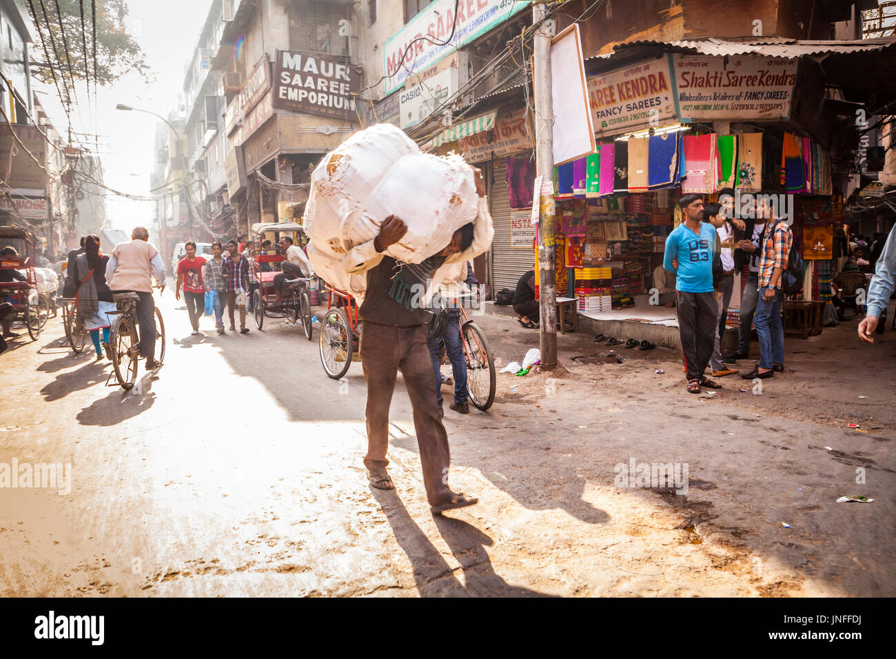 Un homme portant un lourd et difficile charge sur ses épaules à travers les rues de Chandni Chowk, l'un des plus fréquentés et des plus anciens marchés de Delhi, Inde. Banque D'Images