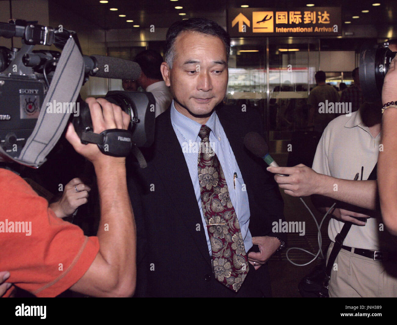 BEIJING, CHINE - un membre de la délégation du Gouvernement japonais est entouré par les photographes et journalistes à son arrivée à l'aéroport de Pékin le 2 septembre en route pour Pyongyang à se préparer pour le premier ministre japonais Junichiro Koizumi en réunion avec le dirigeant nord-coréen Kim Jong Il, il y a 17 septembre. (Kyodo) Banque D'Images