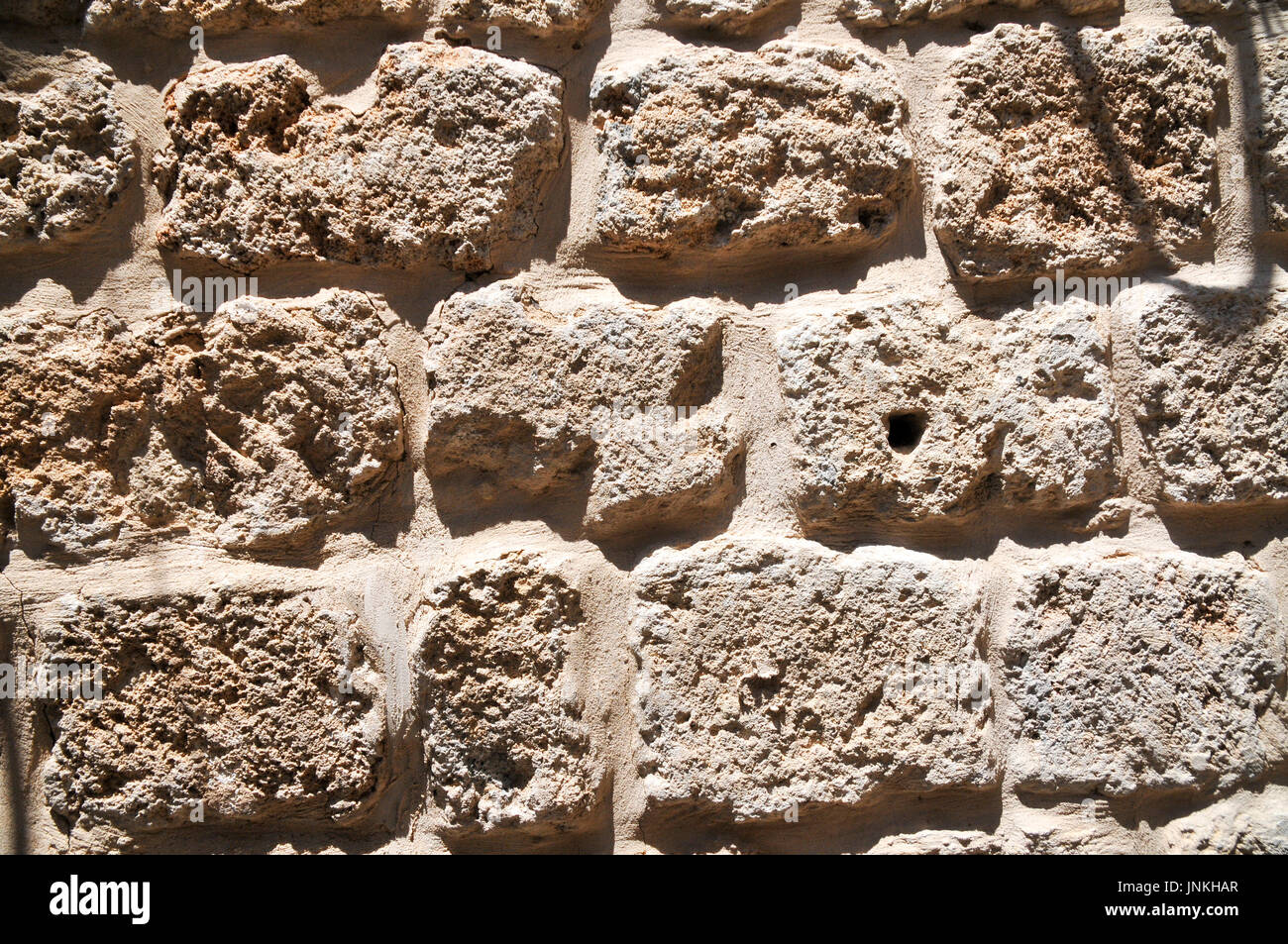 Close up d'un mur construit à partir du pétrole brut de briques Kurkar un grès calcaire fossilisé ou les dunes de sable de mer commun dans Israël. Photographié à Acre Banque D'Images