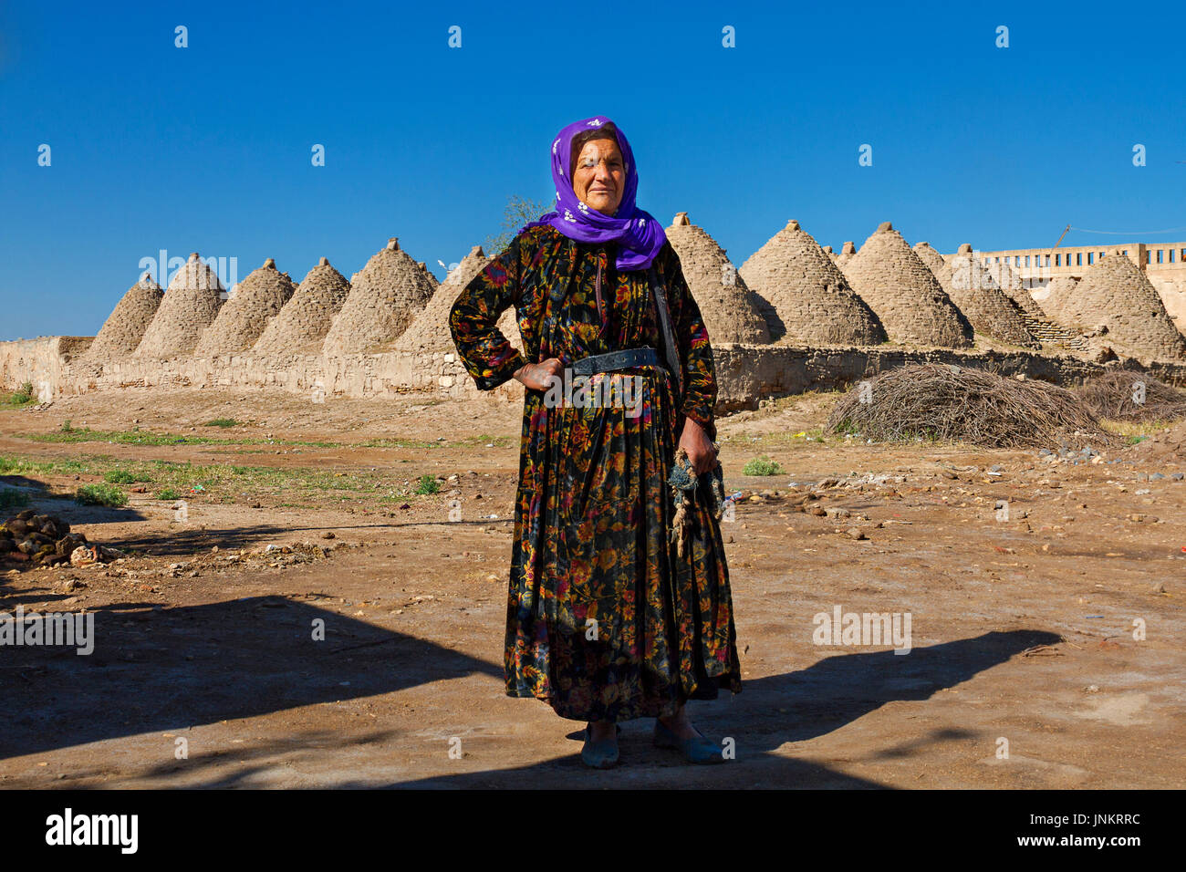 Femme locale avec des maisons en adobe de brique de boue en arrière-plan, dans la ville de Harran, Sanliurfa, Turquie. Banque D'Images