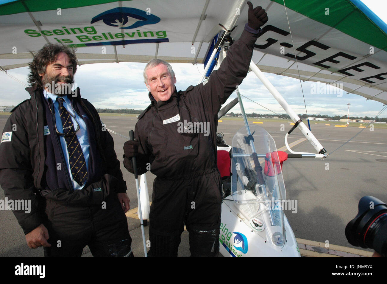 SYDNEY, AUSTRALIE - Miles Hilton-Barber (R) se jette sur son bras dans la joie après avoir touché sa micro-avions légers dans un aéroport, à l'ouest de Sydney, le 30 avril, devenant le premier pilote à voler aveugle jamais plus de la moitié de la planète. Les 58 ans, père de trois britanniques a commencé son aventure à Londres le 7 mars, et avec son assistant myope co-pilotes Richard Hardey et cerveau Milton, a volé de l'aube au crépuscule pour 59 jours, parcourant plus de 19 pays et plus de 20 000 kilomètres pour se rendre à Sydney. (Kyodo) Banque D'Images