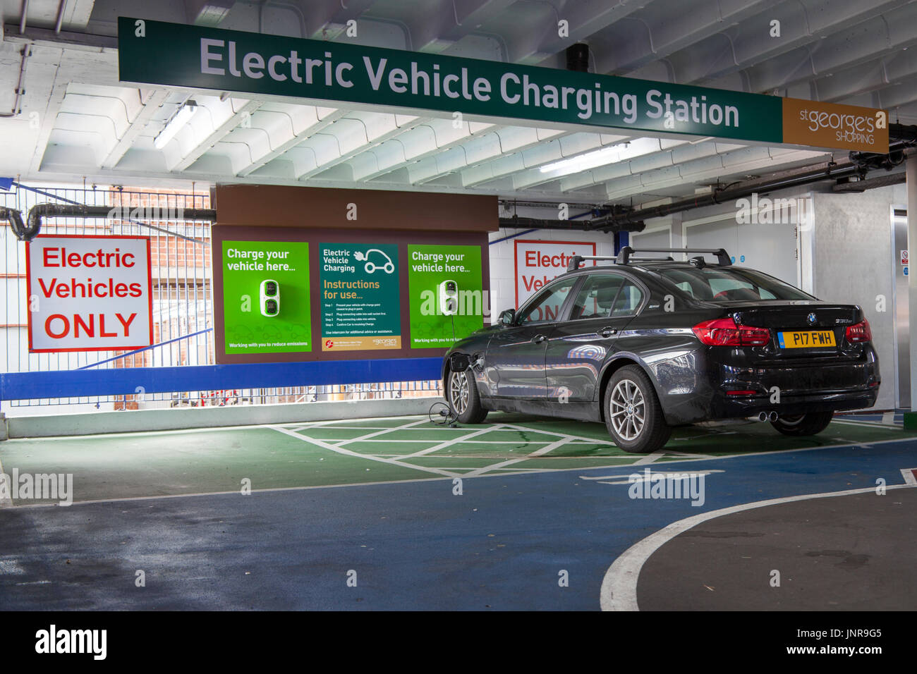 BMW série 3 hybride enfichable garée dans un parking à plusieurs étages. Une station de charge pour véhicule électrique, également appelée station de charge EV, point de recharge électrique, point de charge, point de charge et EVSE à Preston, Lancashire, Royaume-Uni Banque D'Images