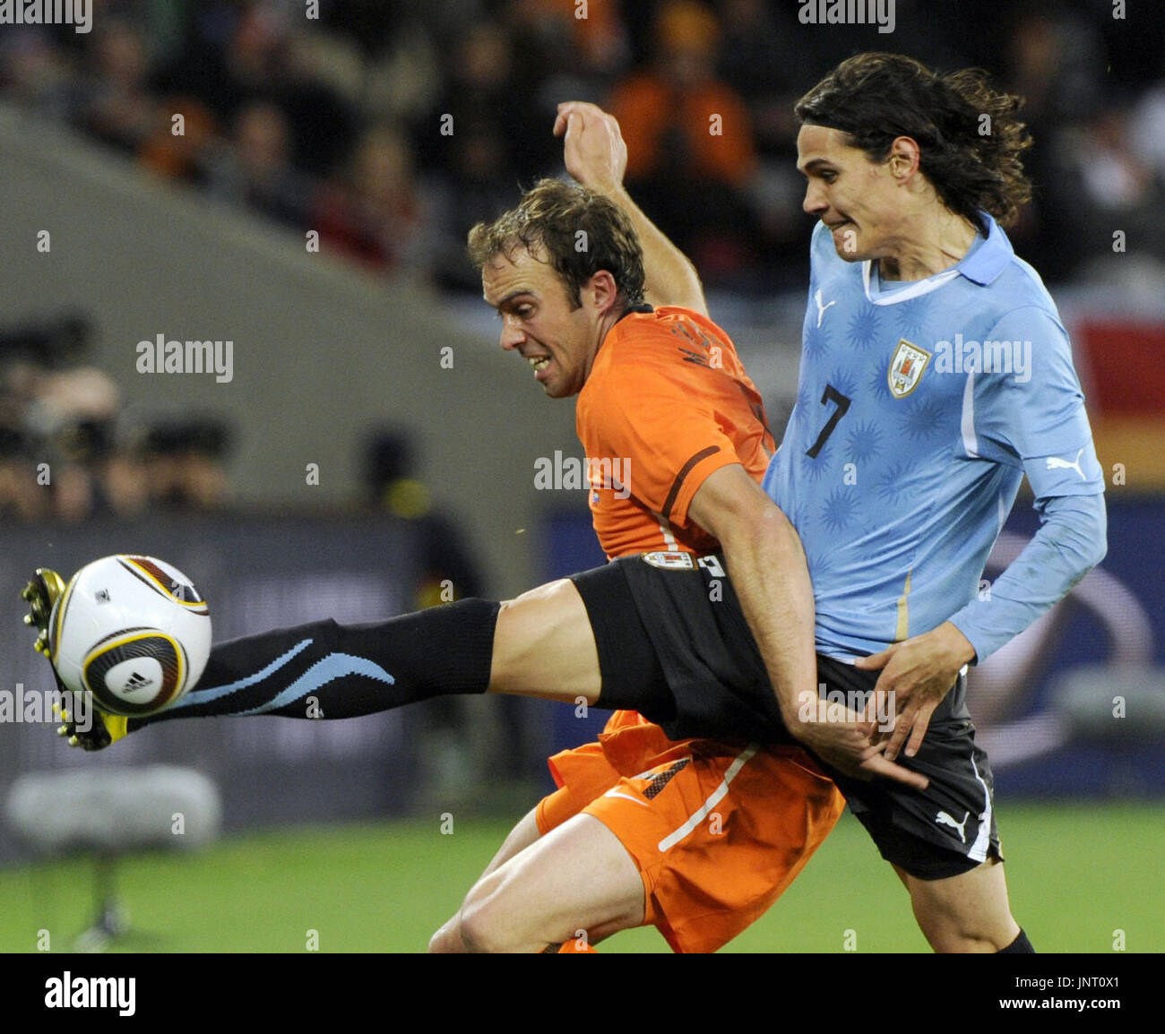CAPE TOWN, AFRIQUE DU SUD - Uruguay attaquant Edinson Cavani (R) bat Pays-bas defender Joris Mathijsen à la balle dans la première moitié d'une demi-finale de la Coupe du Monde au stade Green Point au Cap, Afrique du Sud, le 6 juillet 2010. La France a gagné 3-2. (Kyodo) Banque D'Images