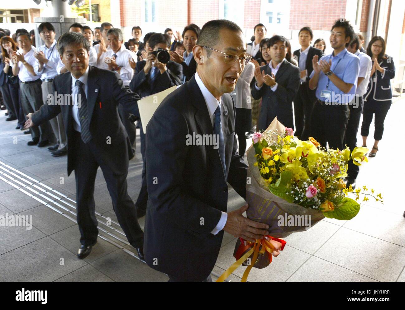 KYOTO, JAPON - scientifique japonais et l'Université de Kyoto le Professeur Shinya Yamanaka (C) entre dans l'université à Kyoto le 9 octobre 2012, de tenir une conférence de presse après avoir reçu des fleurs d'un collègue. Yamanaka, qui a remporté cette année le Prix Nobel de physiologie ou médecine pour ses travaux sur les cellules souches multi-usages dérivés artificiellement, a exprimé sa gratitude aux adjoints dans son laboratoire et les membres de la famille lors d'une conférence de presse à l'université le jour même, un jour après la remise des prix les gagnants ont été annoncés à Stockholm. (Kyodo) Banque D'Images