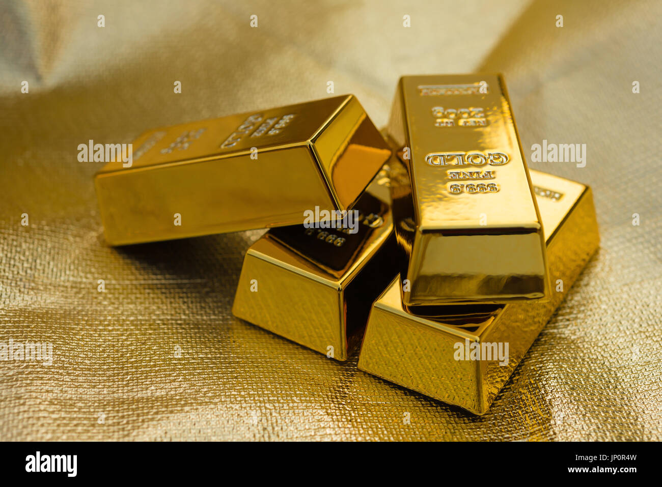 Quatre morceaux de barres d'or sur un fond doré Banque D'Images