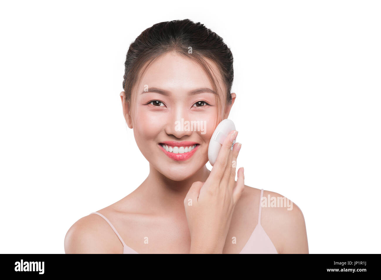 Portrait of attractive young asian woman holding Pinceaux de maquillage over white Banque D'Images