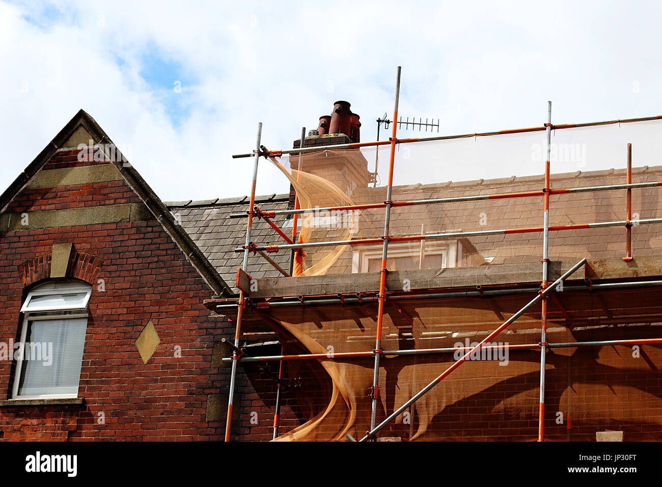 Les échafaudages sur le toit d'un bâtiment en briques rouges Banque D'Images