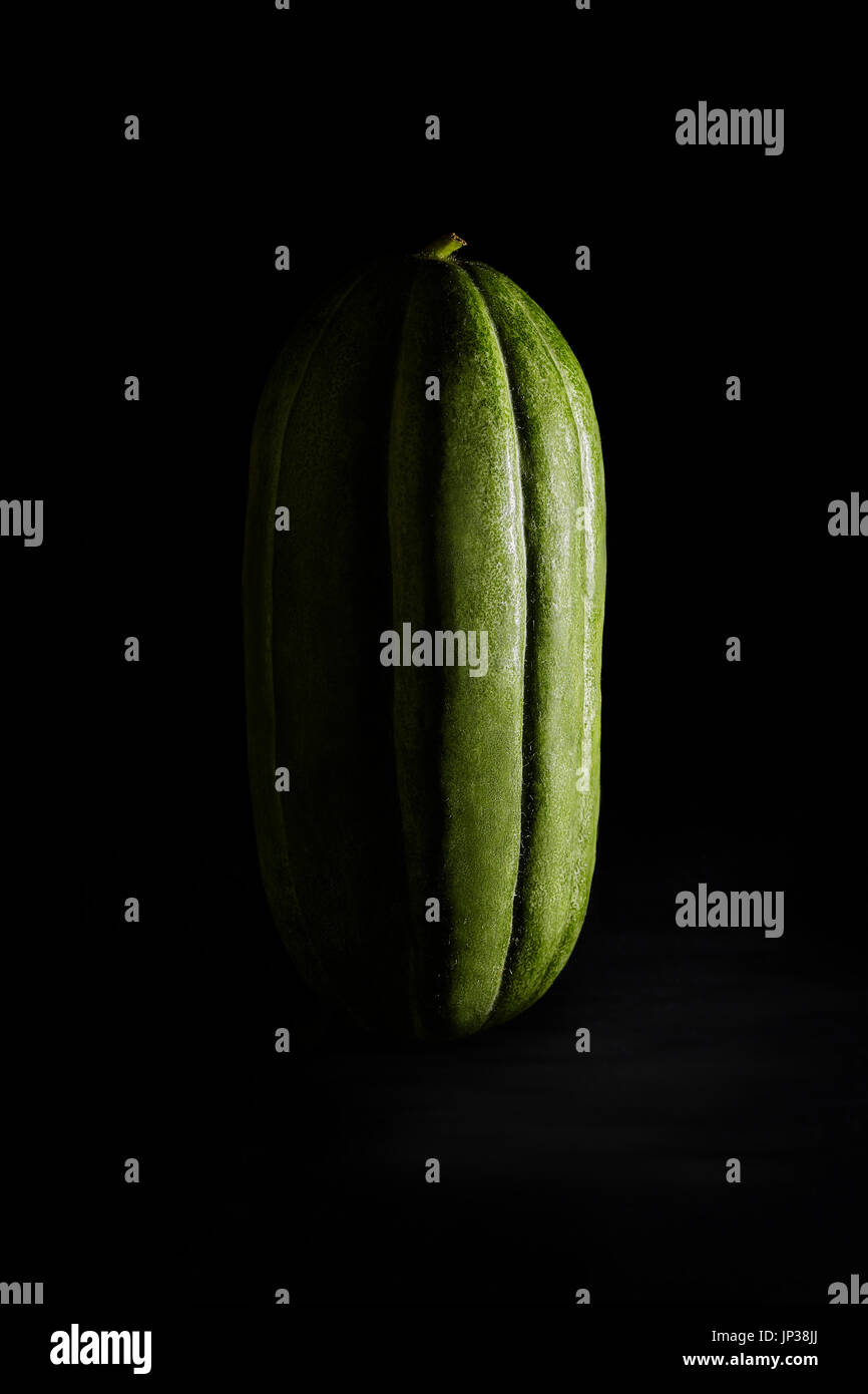 Variété de concombre cultivé en Pouilles, appelé domaine carosello barese (Cucumis melo). Studio shot sur fond noir. Banque D'Images