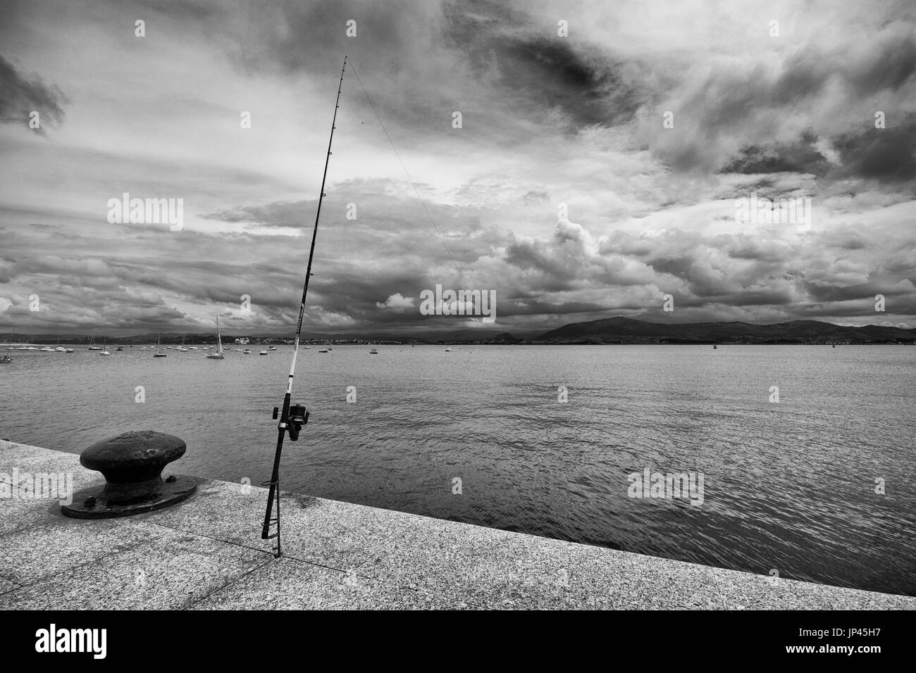 Image en noir et blanc d'une canne à pêche dans la baie de Santander (Santander, Cantabria, Espagne). Banque D'Images