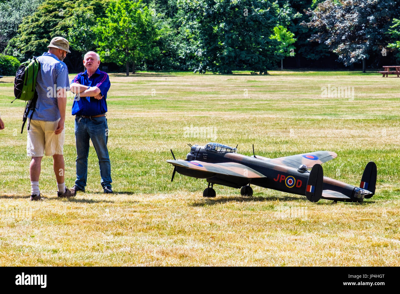 Londres,le parc de Greenwich. Deux hommes debout à côté d'avion militaire modèle avec la peinture de camouflage, deux hommes en avion jouet Banque D'Images