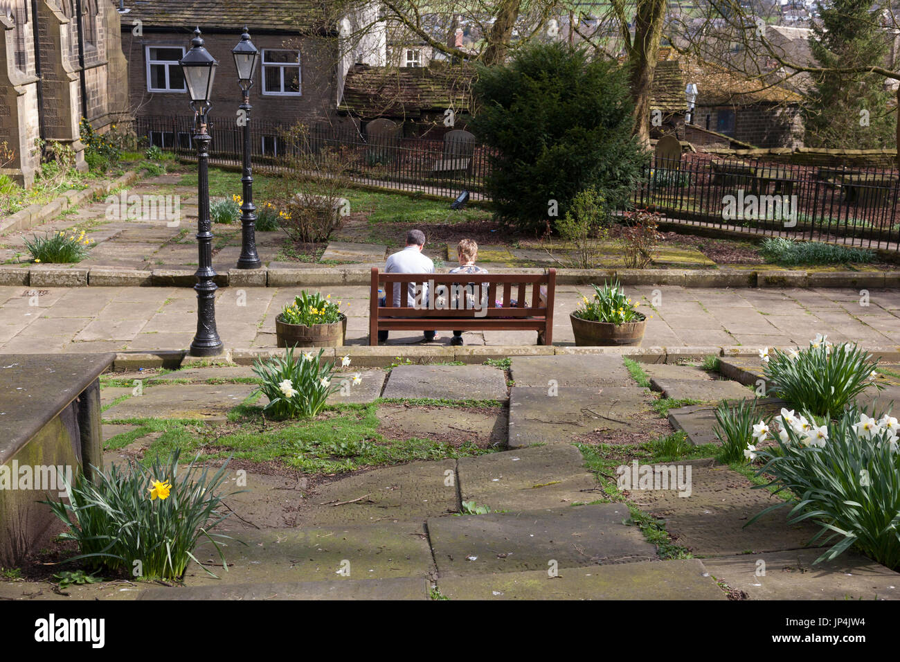 Couple assis sur un banc dans le cimetière, Haworth, West Yorkshire Banque D'Images