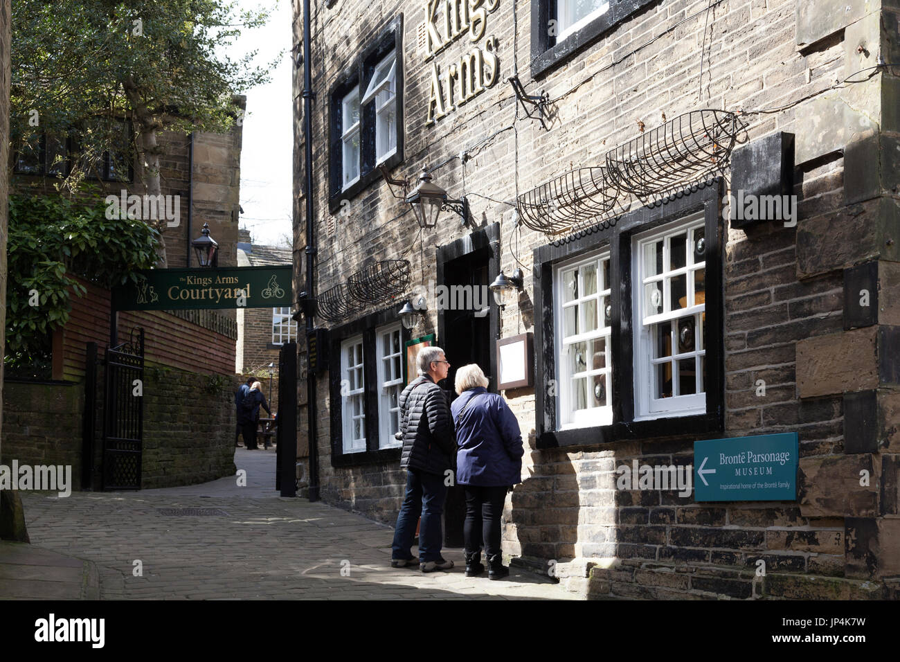Les visiteurs à explorer les rues pavées de Haworth, West Yorkshire Banque D'Images