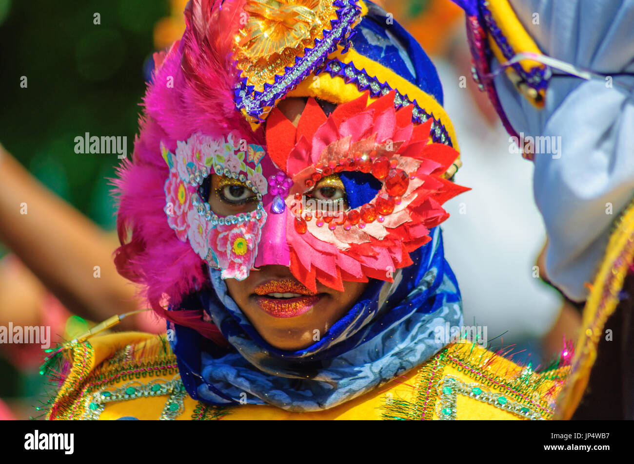 Interprète féminine portant un costume coloré, coiffe et masque sur les rues d'Édimbourg dans le carnaval de la Jazz and Blues Festival Banque D'Images