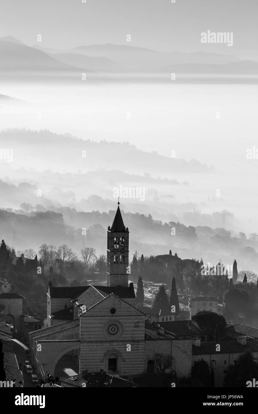 Belle vue sur l'église de sainte Claire d'Assise (Italie) avec du brouillard en dessous et en arrière-plan Banque D'Images