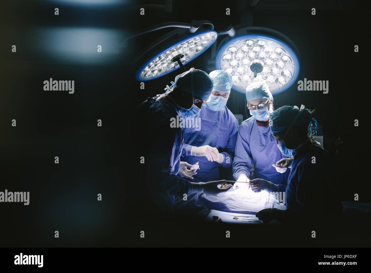 Équipe de chirurgiens d'effectuer la chirurgie dans l'hôpital. Groupe de chirurgiens d'effectuer l'opération sur de patient en salle d'opération. Banque D'Images