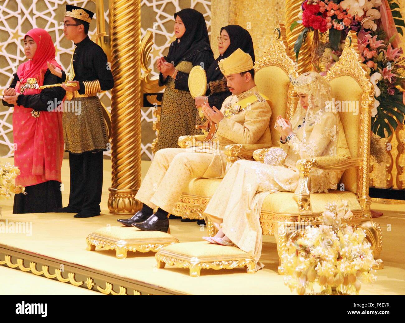 Prince du Brunei Abdul Malik, le 31 ans, deuxième fils du Sultan Hassanal Bolkiah, lie l'instructrice en Dayangku avec nœud Raabi'atul 'Adawiyyah Pengiran Haji Bolkiah, 22, lors d'une cérémonie en avril 2015. Les événements de mariage a duré plus d'une semaine. (Kyodo) = =Kyodo Banque D'Images